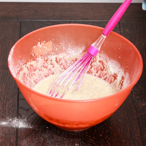 Orange plastic bowl with undone cake — Stock Photo, Image