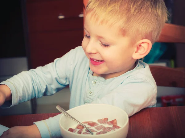 Dítě chlapec jíst snídani, obilovin a mléka v misce — Stock fotografie