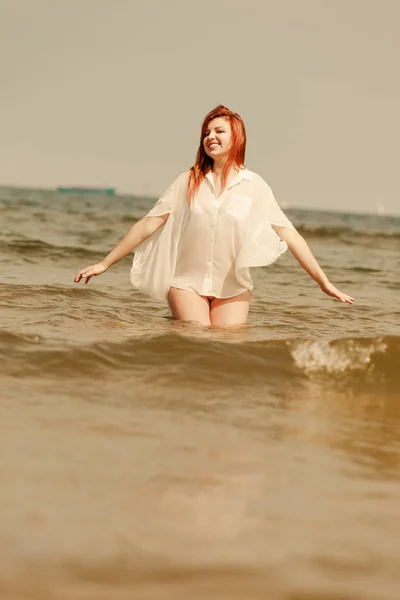 Redhead woman playing in water during summertime — Stock Photo, Image