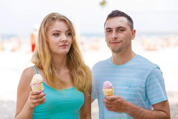 Mężczyzna i kobieta jedzący lody na plaży — Zdjęcie stockowe