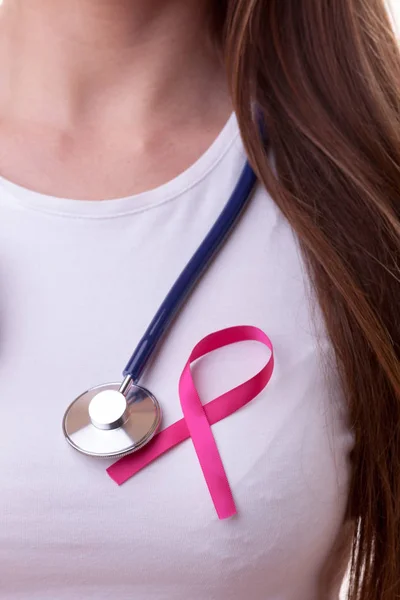 Pink ribbon and stethoscope on female chest — Stock Photo, Image