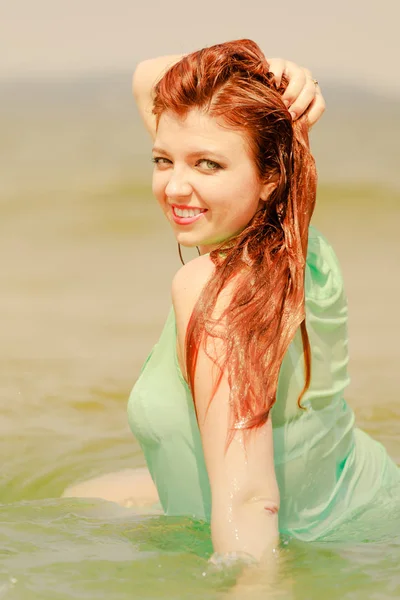 Rossa donna in posa in acqua durante l'estate — Foto Stock