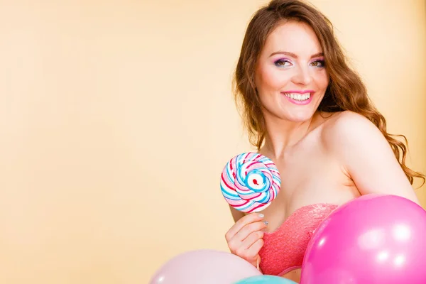 Woman holds lollipop candy and balloons — Stock Photo, Image