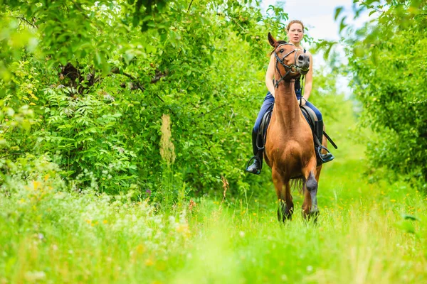 Jeune femme chevauchant un cheval — Photo