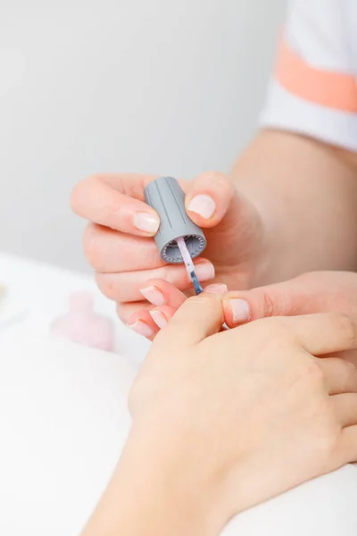 Manicura aplicando esmalte de uñas en uñas de mujer — Foto de Stock