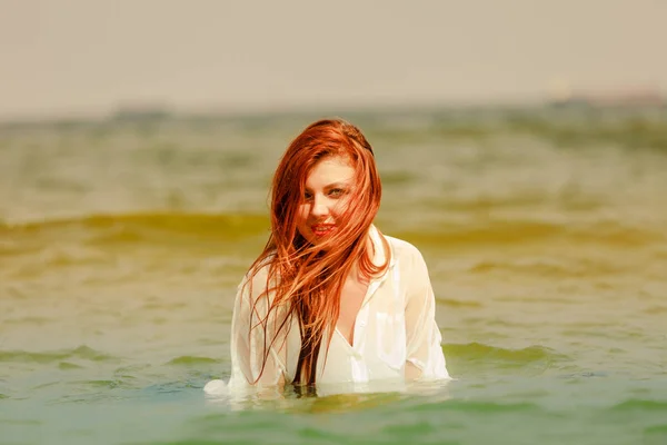 Redhead woman playing in water during summertime — Stock Photo, Image