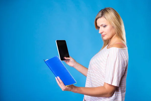 Mulher loira escolhendo entre livro e tablet — Fotografia de Stock