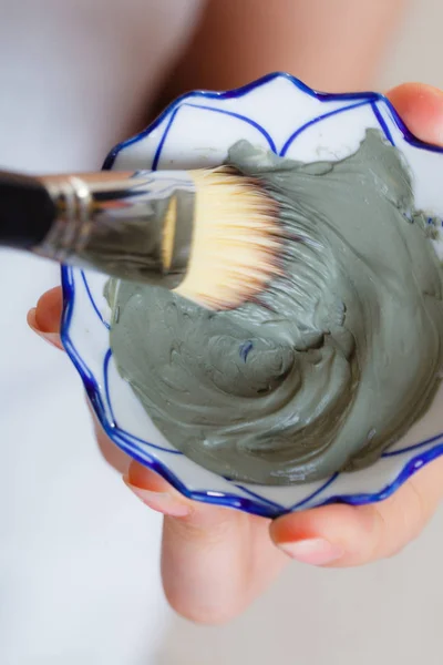 Woman mixing face mask in little porcelain bowl — Stock Photo, Image