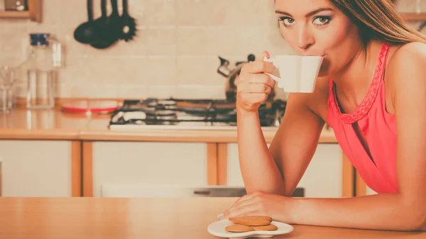 Женщина с пряничным печеньем пьет чай с кофе — стоковое фото