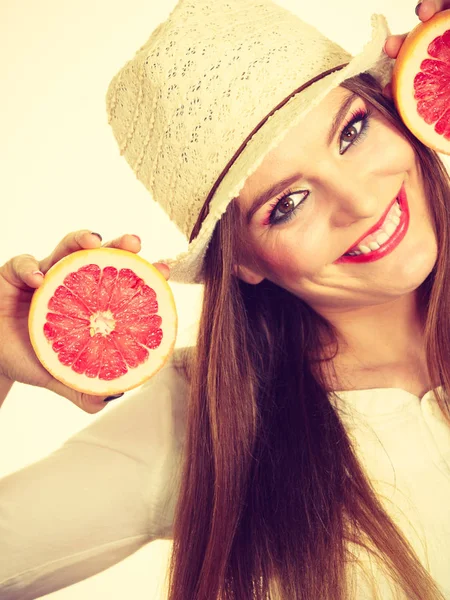 Mulher segura duas metades de frutas cítricas de toranja nas mãos — Fotografia de Stock