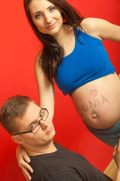 Ventre de femme enceinte, père dessinant dessus — Photo