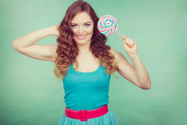 Smiling girl with lollipop candy on teal — Stock Photo, Image