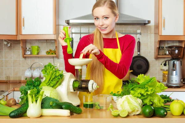 En kvinne på kjøkkenet som lager grønnsakssaft. – stockfoto