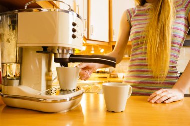 Woman making hot drink in coffee machine clipart