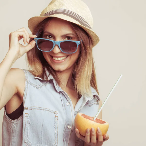 Lycklig kvinna i hatt och solglasögon och grapefrukt — Stockfoto