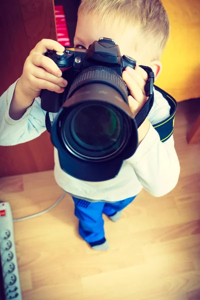 Kid playing with big professional digital camera — Stock Photo, Image