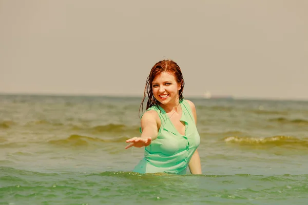 Redhead woman playing in water during summertime — Stock Photo, Image