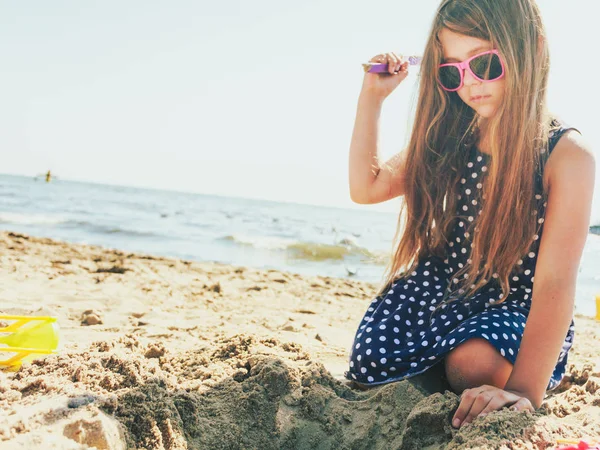 Schönes wunderschönes kleines Mädchen, das mit Sand spielt. — Stockfoto