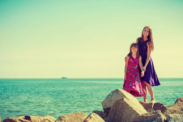 Mãe e filha posando em rochas do mar — Fotografia de Stock