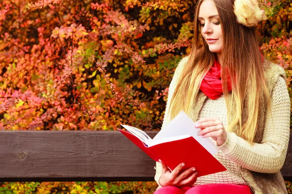 Frau entspannt sich im herbstlichen Park beim Lesen von Buch — Stockfoto