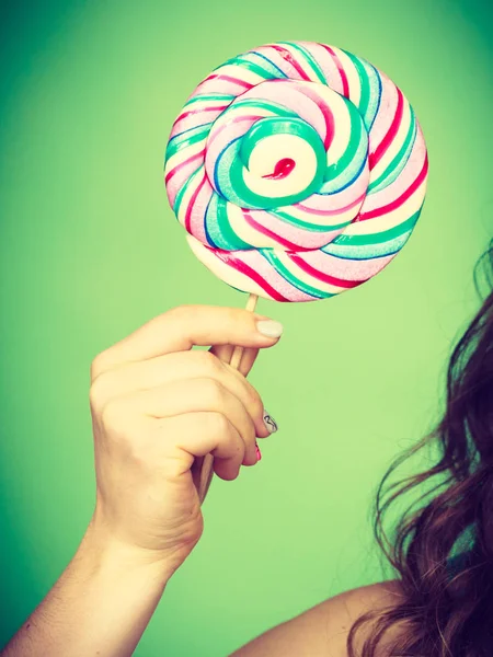 Kvinnlig hand håller färgglada lollipop godis — Stockfoto