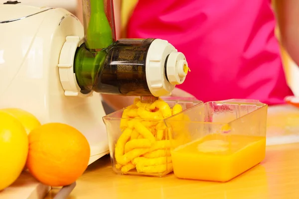 Vrouw maken van sinaasappelsap in juicer machine — Stockfoto