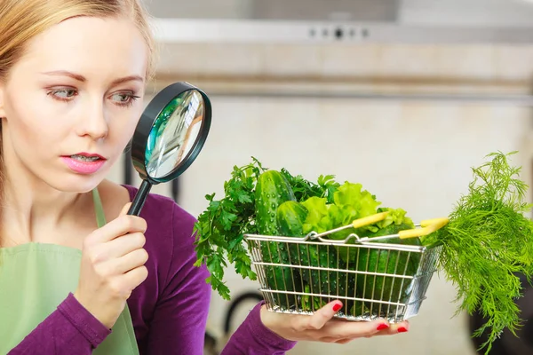 Femme regardant à travers loupe panier de légumes — Photo