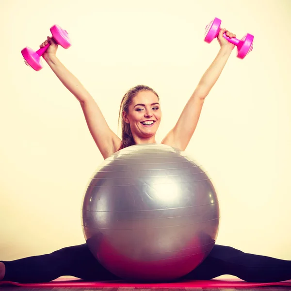 Meisje warming-up met bal en stom bel gewichten. — Stockfoto