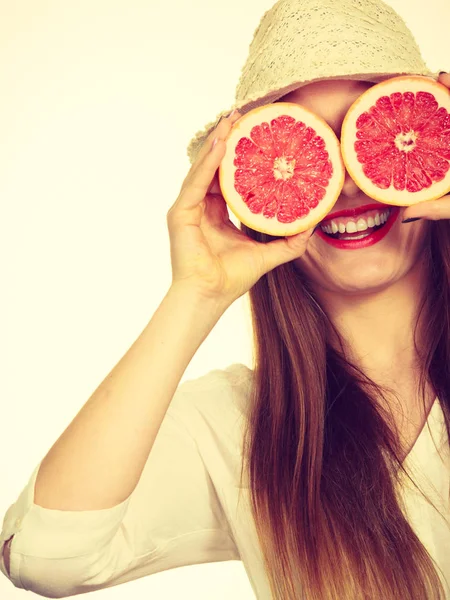 Vrouw houdt twee helften pompelmoes citrusvruchten in handen — Stockfoto