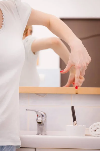 Mão feminina apontando na tigela com máscara de barro. Cuidados da pele . — Fotografia de Stock