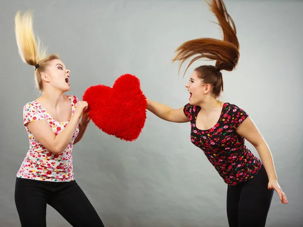 Dos mujeres agresivas discutiendo pelean sosteniendo el corazón — Foto de Stock