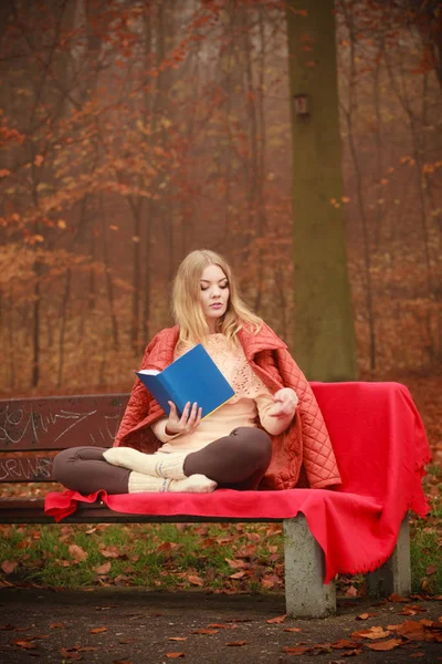 Menina loira lendo livro no outono cenário — Fotografia de Stock