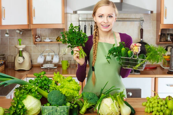 Žena v kuchyni zeleninu drží nákupní košík — Stock fotografie
