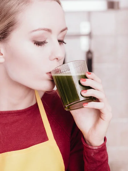 Woman in kitchen holding vegetable smoothie juice — Stock Photo, Image