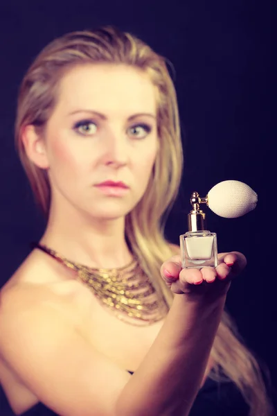 Beautiful woman with necklace holding perfume — Stock Photo, Image