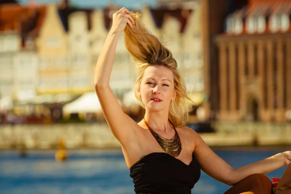 Woman combing her hair with fingers, glamorous outfit — Stock Photo, Image