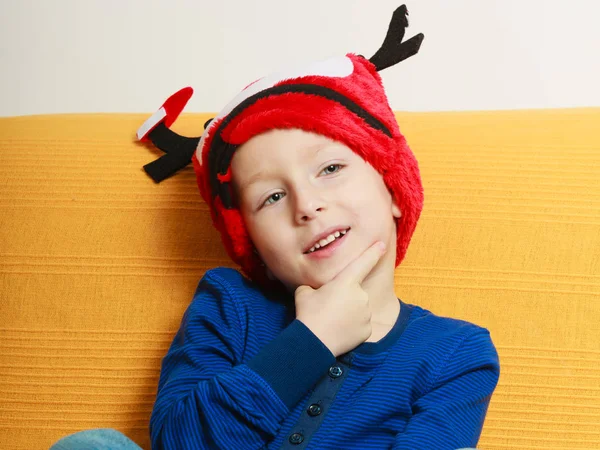 Niño en el sofá con sombrero de Navidad — Foto de Stock