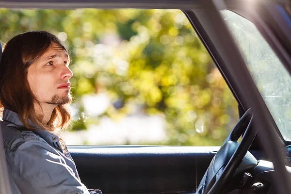 Jeune homme aux cheveux longs voiture de conduite — Photo