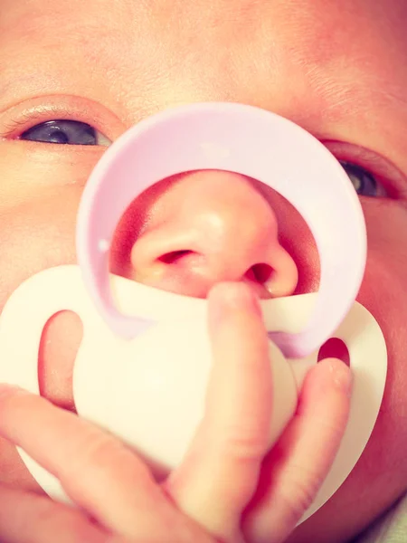 Closeup of little newborn lying with teat in mouth — Stock Photo, Image