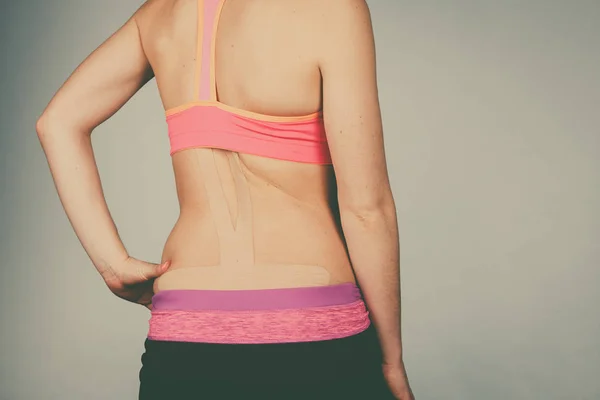 Женщина с медицинским кинезио на спине — стоковое фото