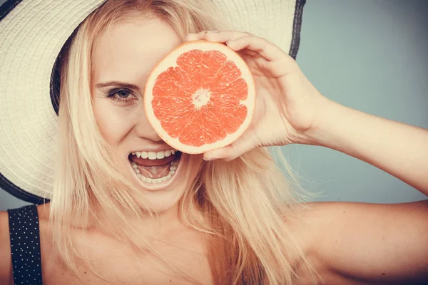 Mujer sosteniendo toronja roja fruta desgaste sombrero de sol — Foto de Stock