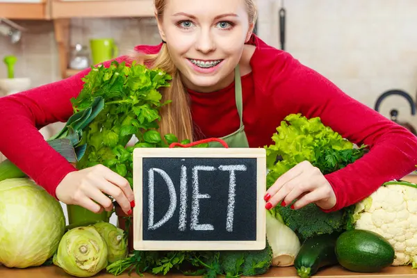 Femme dans la cuisine ayant des légumes de régime vert — Photo