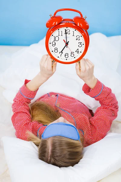 Spící žena nosí pyžamo drží hodiny Stock Snímky