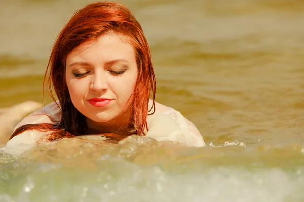 Rusovláska žena pózuje ve vodě v létě — Stock fotografie