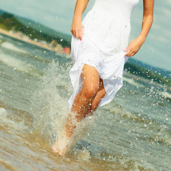 Mulher loira vestindo vestido andando na água — Fotografia de Stock