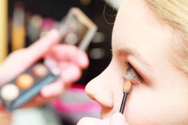 Close-up van vrouw krijgen make-up, oogschaduw — Stockfoto
