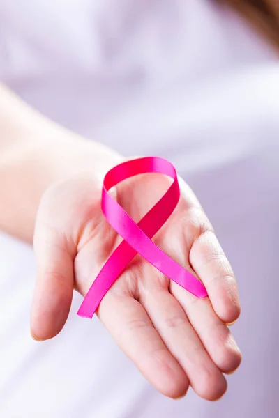 Woman with breast cancer awareness ribbon on hand — Stock Photo, Image