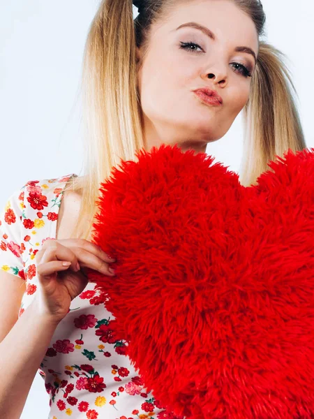 Mujer feliz sosteniendo almohada en forma de corazón — Foto de Stock