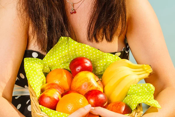 Woman holding picnic basket with fruits — Stock Photo, Image