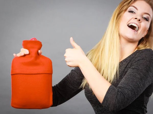 Mujer sosteniendo caliente botella de agua caliente rojo — Foto de Stock